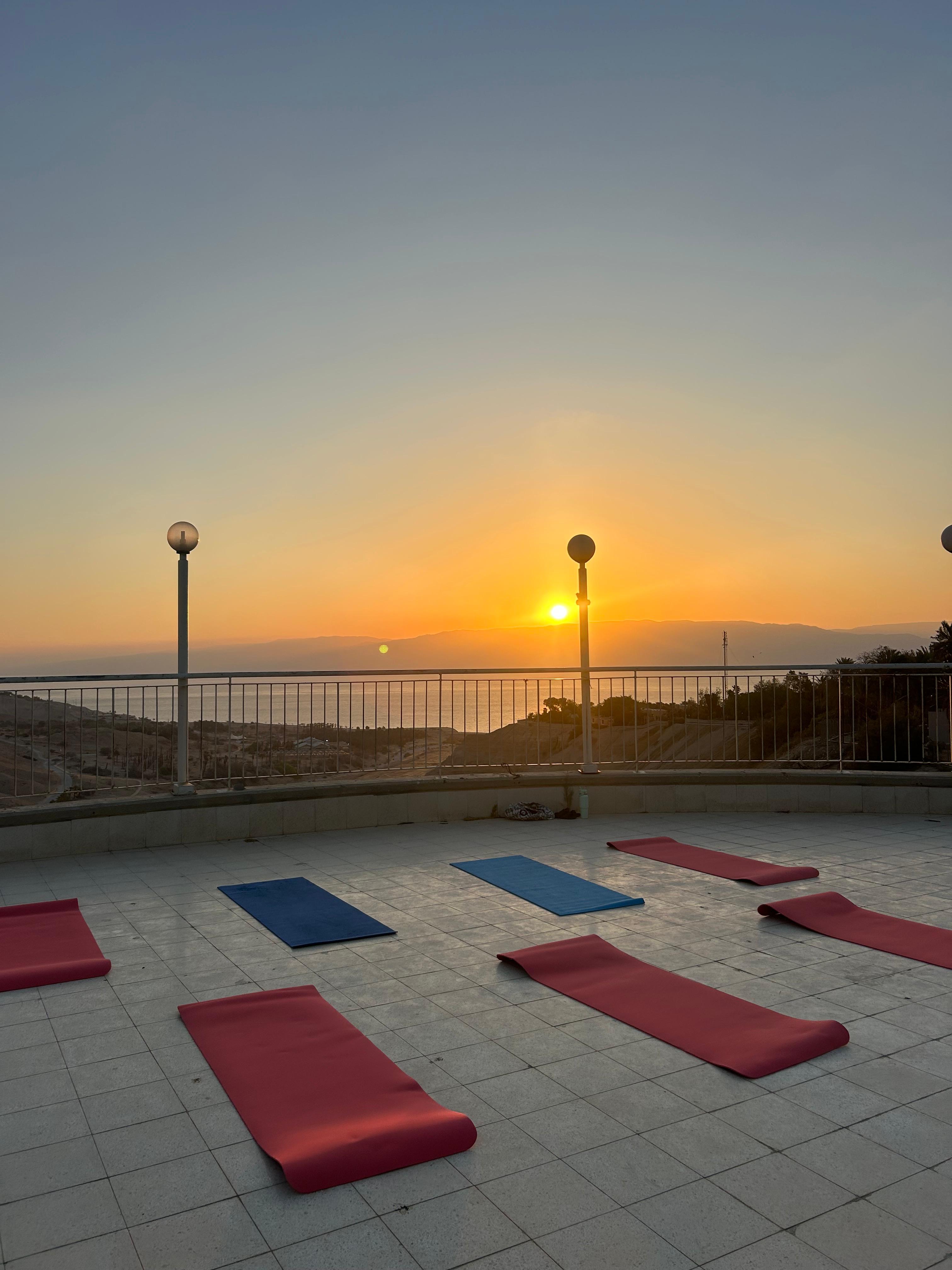 שיעור יוגה על גג מול השמש השוקעת